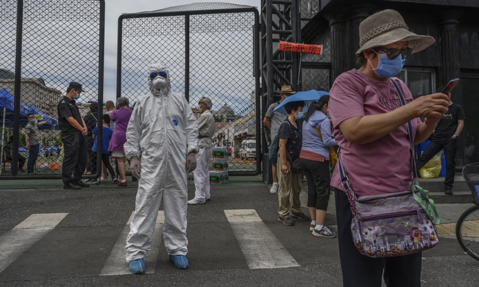 Un trabajador de control de epidemias dirige a las personas a una estación de prueba de coronavirus en Beijing, China, mientras las autoridades abordan el brote más significativo en el país desde febrero.